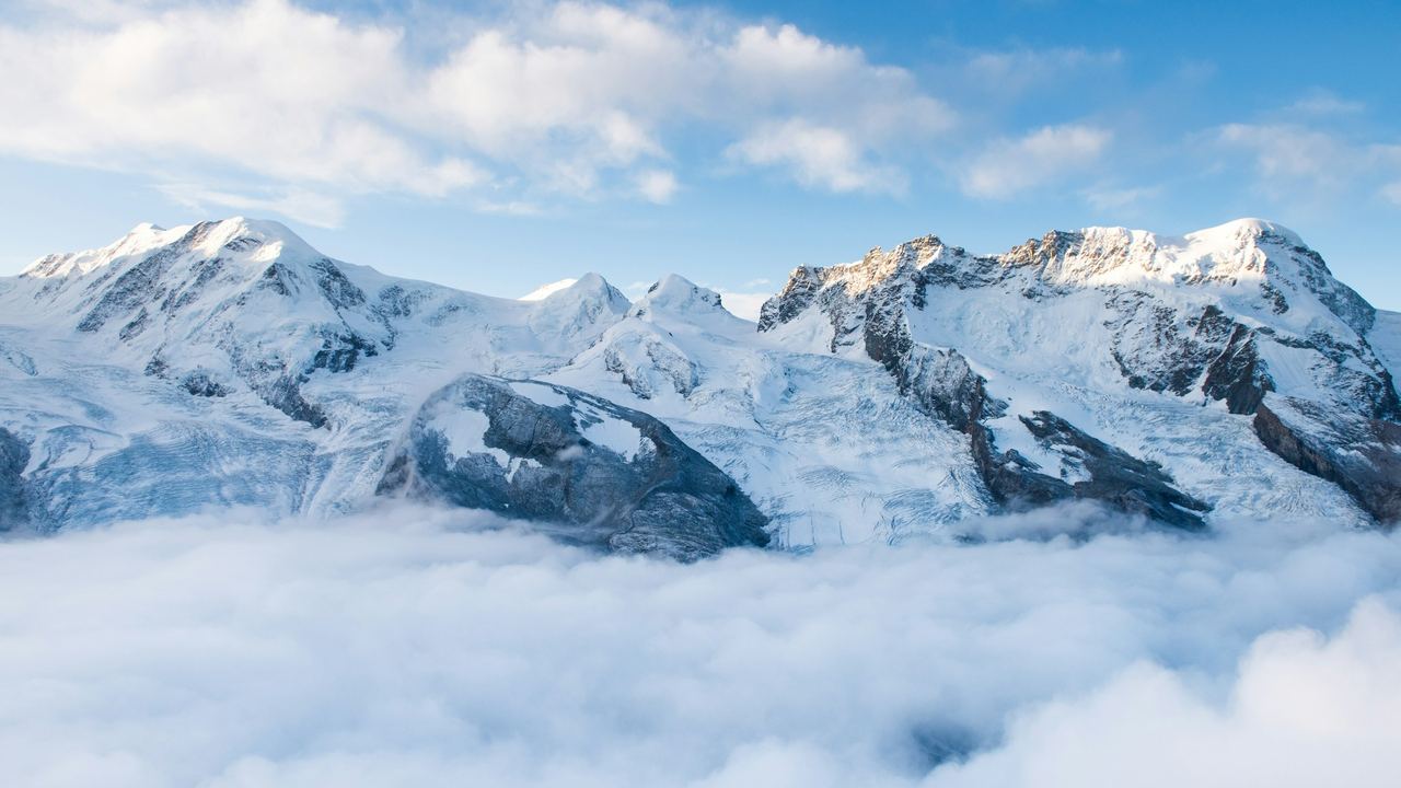 Snow peaks above a sea of cloud