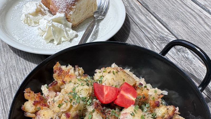 Lunch at a mountain hut: bacon dumplings on sauerkraut in an iron pan, and a sweet bun with cream