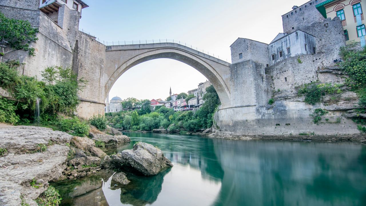 Mostar's Old Bridge arching over the green Neretva between stone towers