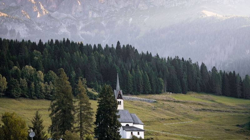 Chalets and green meadows below the pale Dolomite walls at Cortina d’Ampezzo