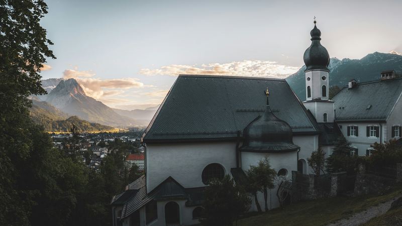 The pilgrimage church of St. Anton above Garmisch-Partenkirchen at sunset, with the Alpspitze beyond