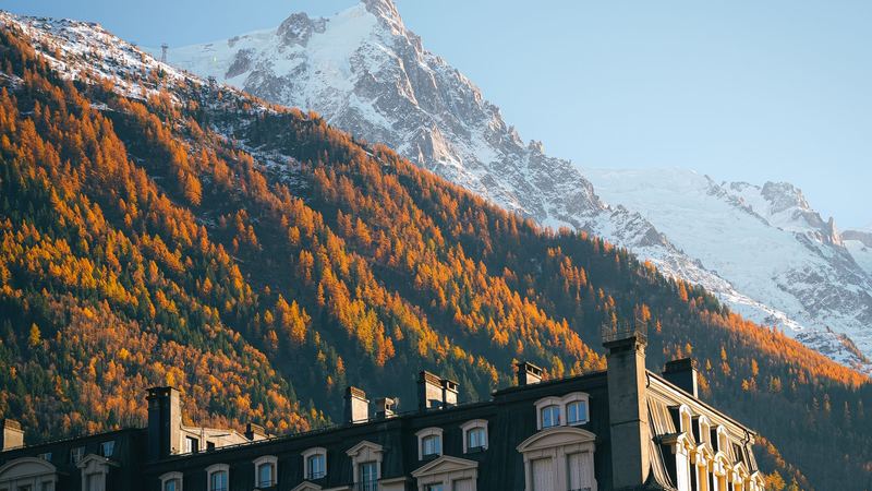 Larches in autumn gold below the Aiguille du Midi, with a grand old hotel of Chamonix