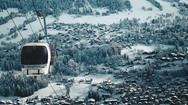 A Megève gondola above the snow-covered village, the pistes and the peaks