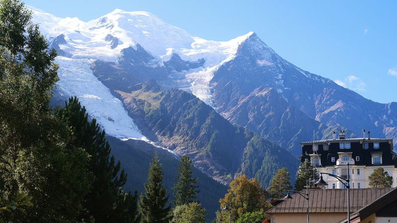 Mont Blanc and the Bossons glacier above the trees and a Belle Époque hotel of Chamonix