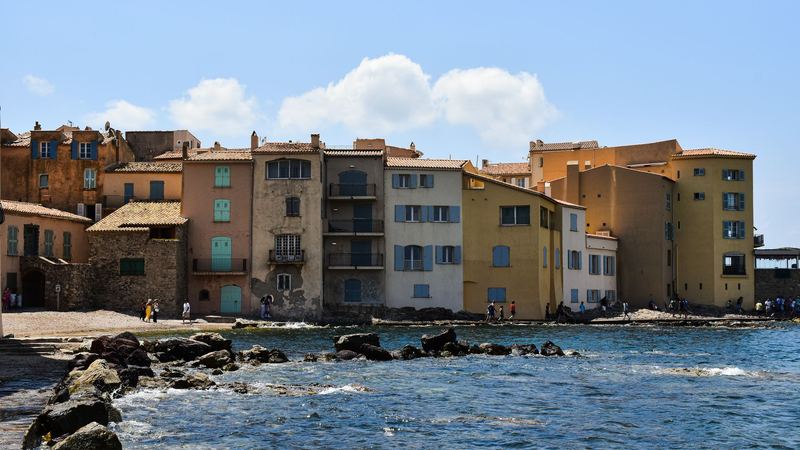 The pastel houses of La Ponche in Saint-Tropez, with blue and green shutters, along the edge of the sea