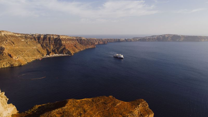 A cruise ship crossing the caldera of Santorini below the cliffs of Fira