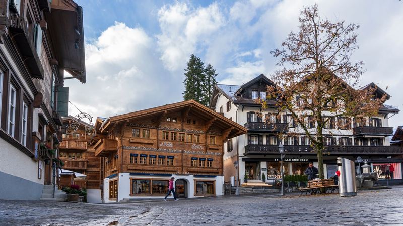 Carved wooden chalets housing Prada, Brunello Cucinelli and Moncler on the cobbled Promenade in Gstaad