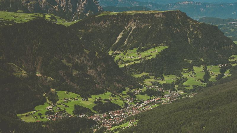 Val Gardena and the green meadows above Ortisei, with the Sciliar cliff beyond