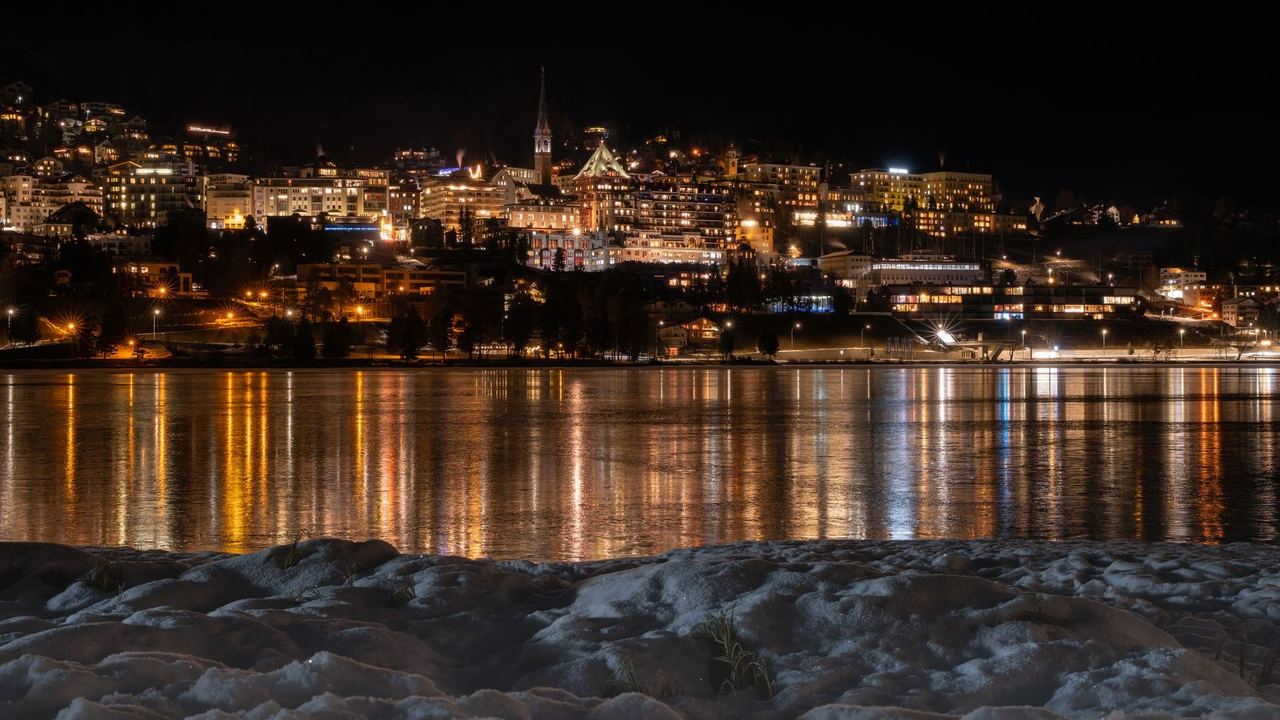 St. Moritz lit up across its lake at night