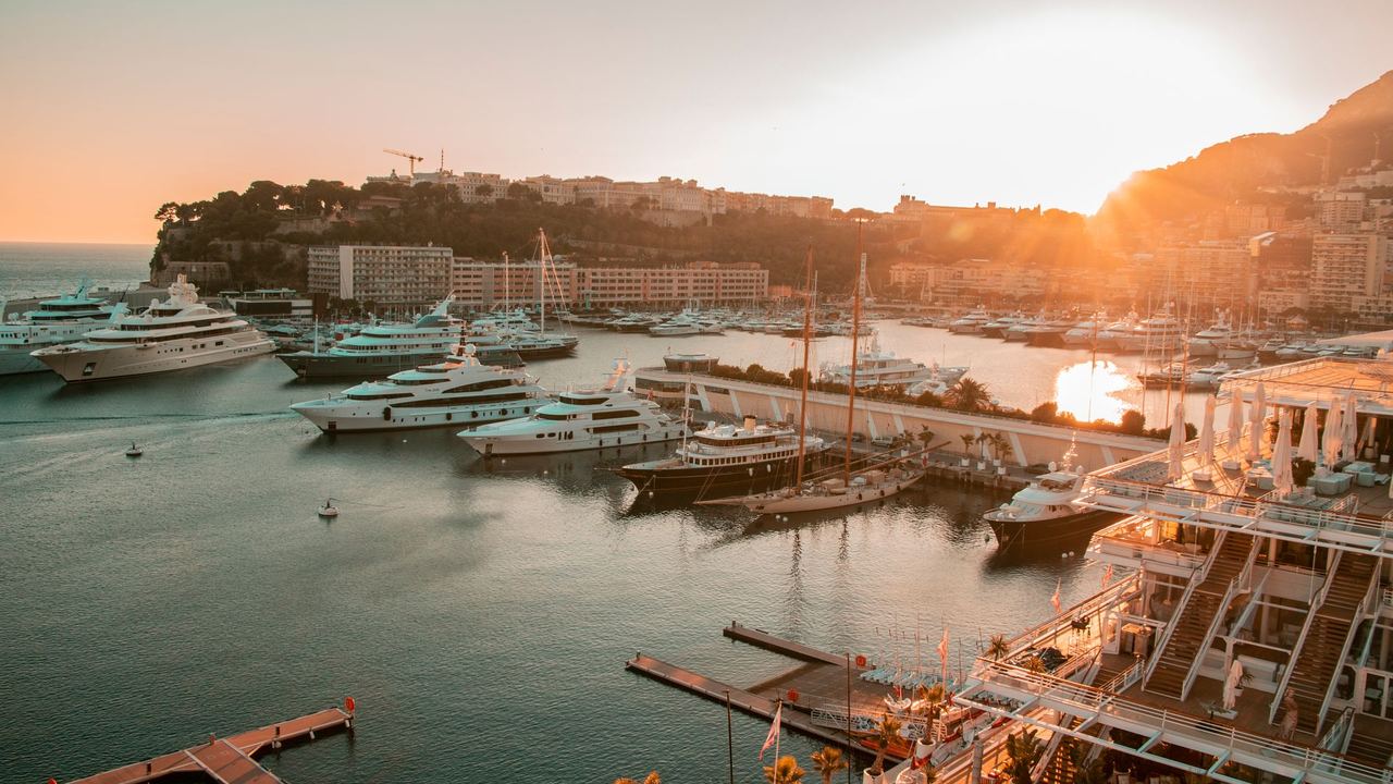 Superyachts in Port Hercule below the Rock of Monaco at sunset