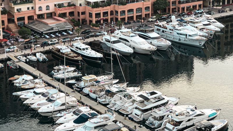 Motor yachts in rows in the marina of Fontvieille below its pink apartment buildings