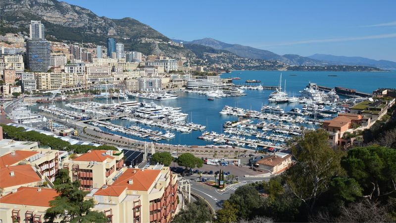 Port Hercule full of yachts below Monte-Carlo, with the mountains and the coast towards Italy beyond
