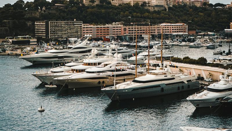 Motor yachts moored in rows in Port Hercule, the old town on the Rock beyond