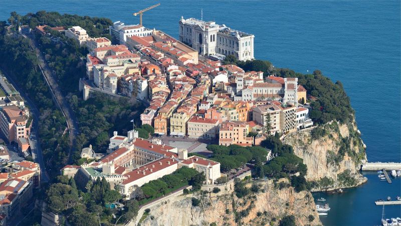 The Rock of Monaco from the air: the Prince's Palace, the old town, the cathedral and the Oceanographic Museum above a deep blue sea