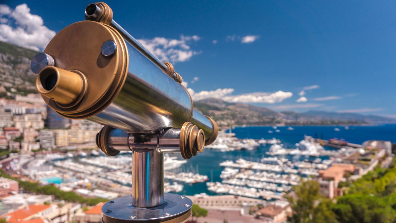 A brass telescope above Port Hercule and Monte-Carlo, the coast of the Riviera beyond