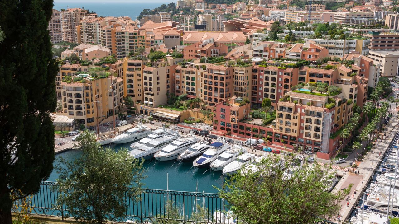 Superyachts moored in the harbour of Fontvieille below the terraced apartments of Monaco
