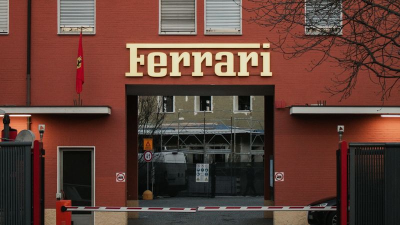 The old factory gate of Ferrari in Maranello, its name in gold above the arch
