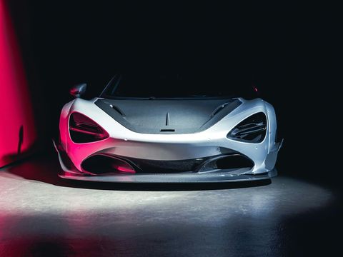 A silver McLaren 720S under studio light