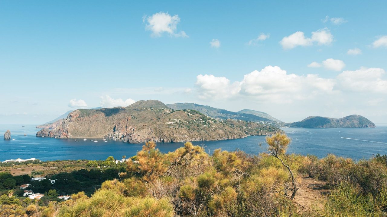 Vulcano and its bays from Lipari, sailing yachts at anchor below the cliffs, the Aeolian Islands