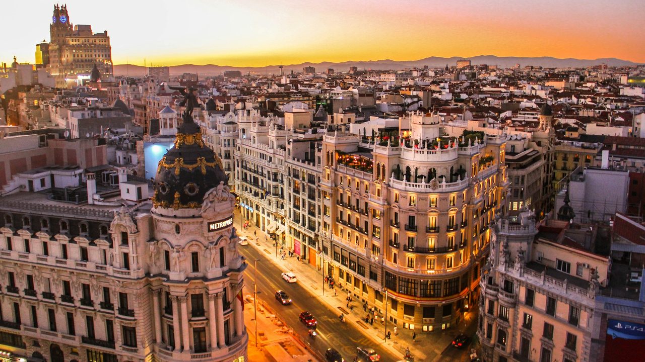 The Metropolis Building and the Gran Vía at sunset, the Sierra de Guadarrama beyond