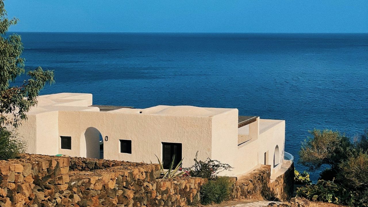 A white house above the sea among dry-stone walls and low vines, Pantelleria