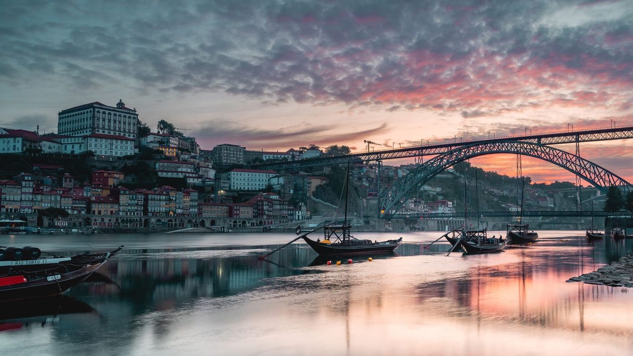 The Dom Luís I bridge and the Ribeira at sunset, port wine boats on the Douro