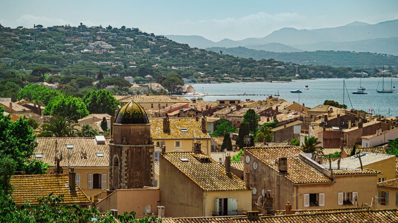 The tiled rooftops and church bell tower of Saint-Tropez above the bay