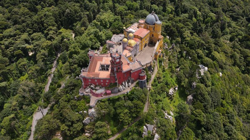 The red and yellow Pena Palace on its wooded hilltop above Sintra, seen from the air