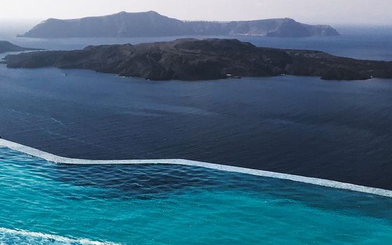 An infinity pool on a Greek clifftop above the Aegean and its islands