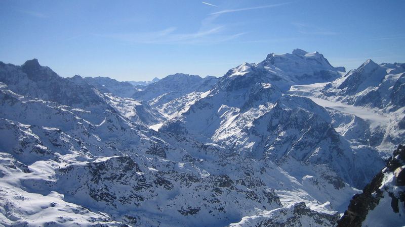 The Grand Combin and its glaciers across a sea of snowy peaks, seen from Mont Fort